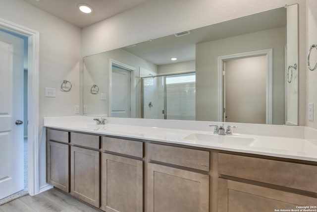 bathroom with hardwood / wood-style floors, vanity, and walk in shower