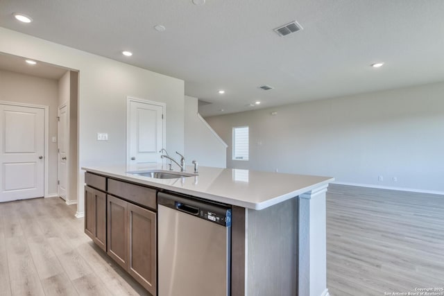 kitchen featuring sink, light hardwood / wood-style floors, stainless steel dishwasher, and an island with sink