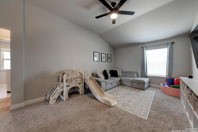 recreation room featuring ceiling fan, light colored carpet, a healthy amount of sunlight, and lofted ceiling