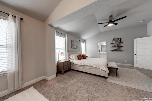 bedroom featuring carpet, ensuite bathroom, vaulted ceiling, and ceiling fan