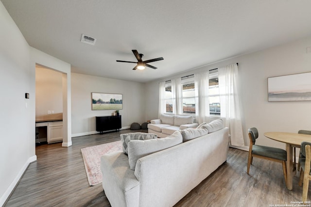 living room featuring dark hardwood / wood-style floors and ceiling fan