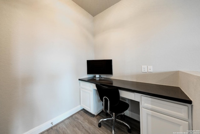 office space with built in desk and light wood-type flooring