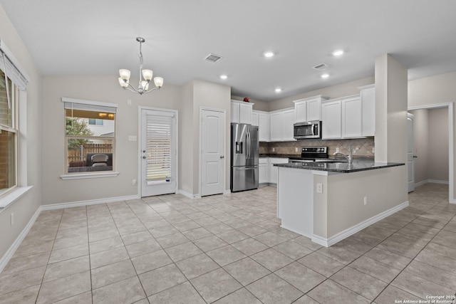 kitchen featuring hanging light fixtures, white cabinetry, light tile patterned flooring, kitchen peninsula, and stainless steel appliances