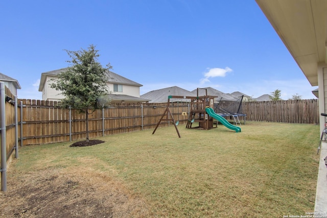 view of jungle gym featuring a lawn and a trampoline