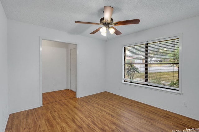 empty room with hardwood / wood-style floors, a textured ceiling, and ceiling fan