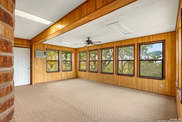 unfurnished sunroom featuring a wall unit AC and ceiling fan