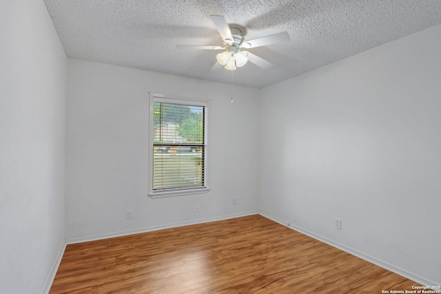 unfurnished room with ceiling fan, wood-type flooring, and a textured ceiling