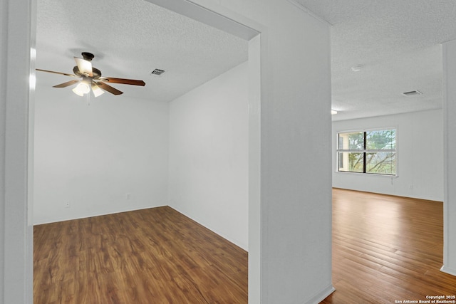 spare room with hardwood / wood-style flooring, ceiling fan, and a textured ceiling