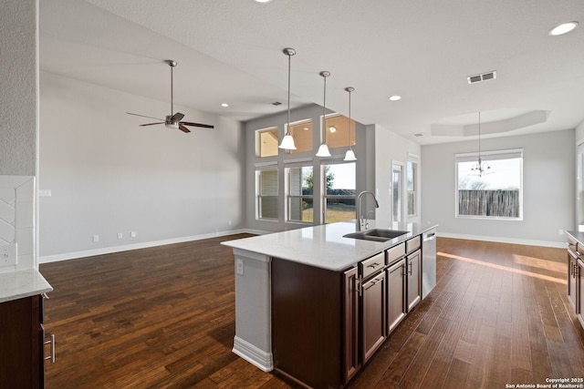 kitchen featuring dark brown cabinetry, dark hardwood / wood-style floors, hanging light fixtures, and sink