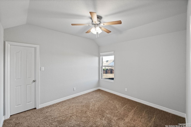 carpeted spare room featuring vaulted ceiling and ceiling fan