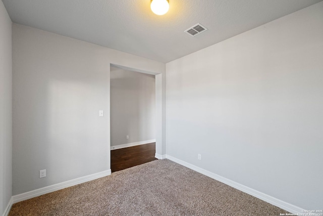 unfurnished room with carpet flooring and a textured ceiling