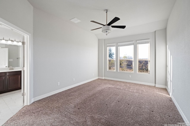 spare room featuring light carpet, vaulted ceiling, ceiling fan, and sink