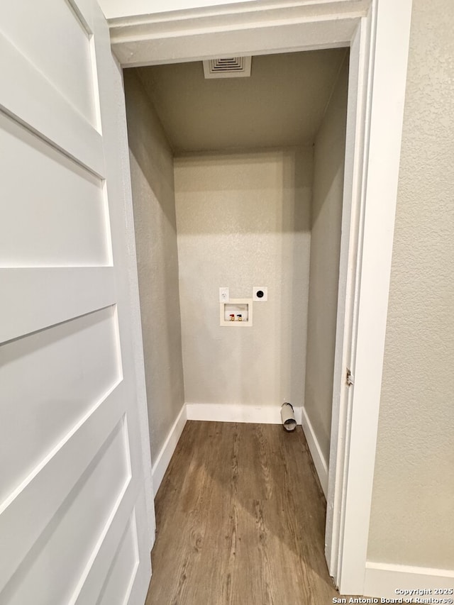 laundry area with hookup for an electric dryer, hookup for a washing machine, and hardwood / wood-style flooring