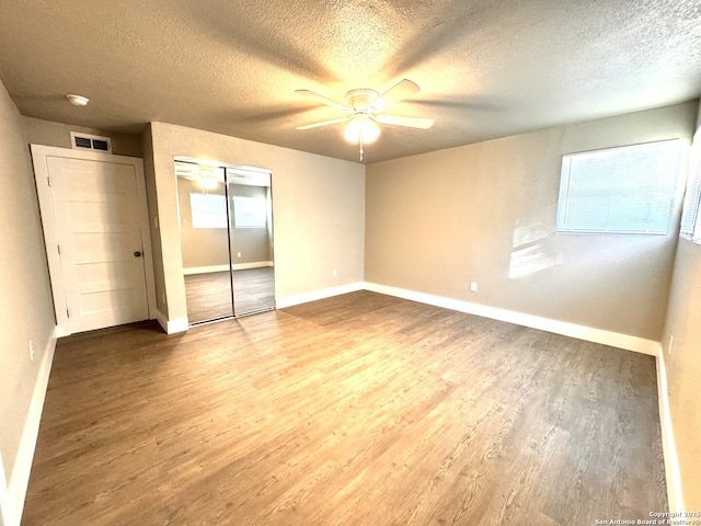 unfurnished bedroom featuring ceiling fan, hardwood / wood-style floors, and a textured ceiling