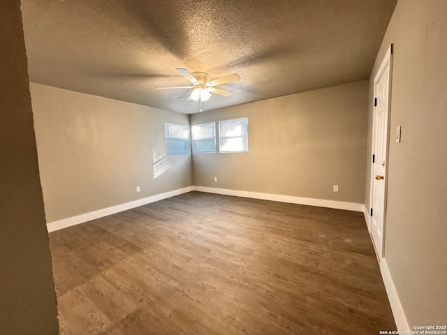 unfurnished room with ceiling fan, dark wood-type flooring, and a textured ceiling