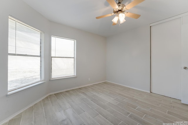 spare room featuring plenty of natural light, ceiling fan, and light wood-type flooring