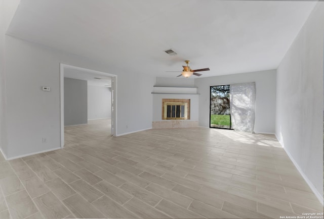 unfurnished living room with ceiling fan and a fireplace