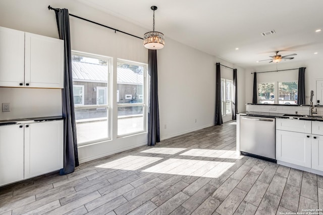 kitchen featuring white cabinets, a wealth of natural light, sink, pendant lighting, and dishwasher