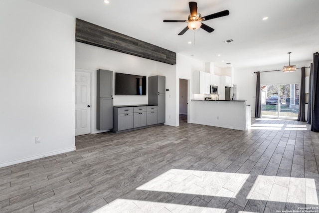 unfurnished living room with ceiling fan