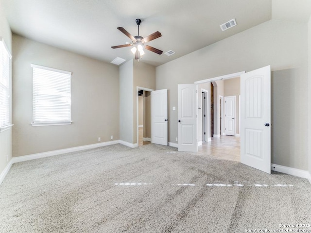 unfurnished bedroom featuring ceiling fan, lofted ceiling, and light carpet