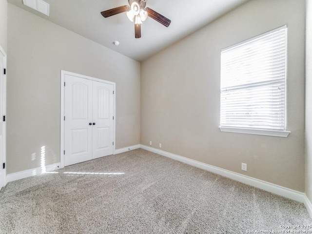 carpeted spare room featuring ceiling fan