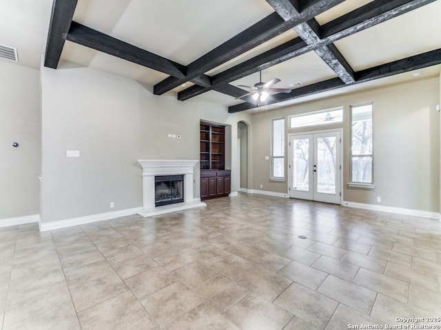 unfurnished living room with beamed ceiling, french doors, ceiling fan, and coffered ceiling