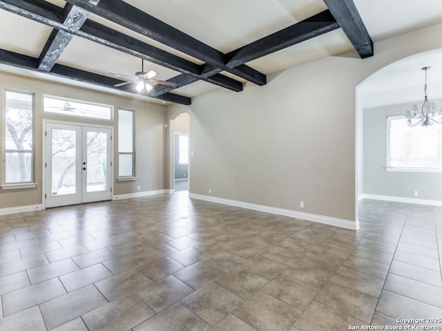 tiled spare room featuring beam ceiling, french doors, a healthy amount of sunlight, and ceiling fan with notable chandelier