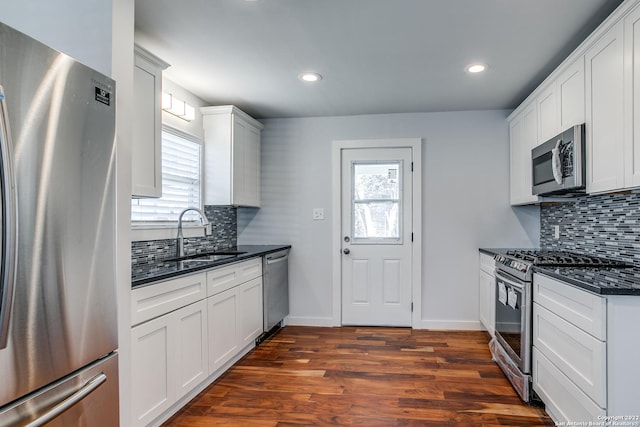 kitchen with dark hardwood / wood-style flooring, stainless steel appliances, white cabinetry, and a wealth of natural light