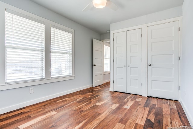 unfurnished bedroom with a closet, hardwood / wood-style flooring, and ceiling fan