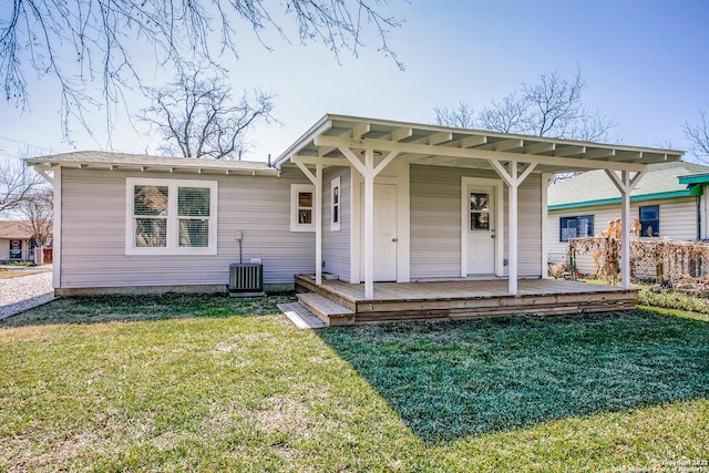 view of front of home with central AC unit and a front yard