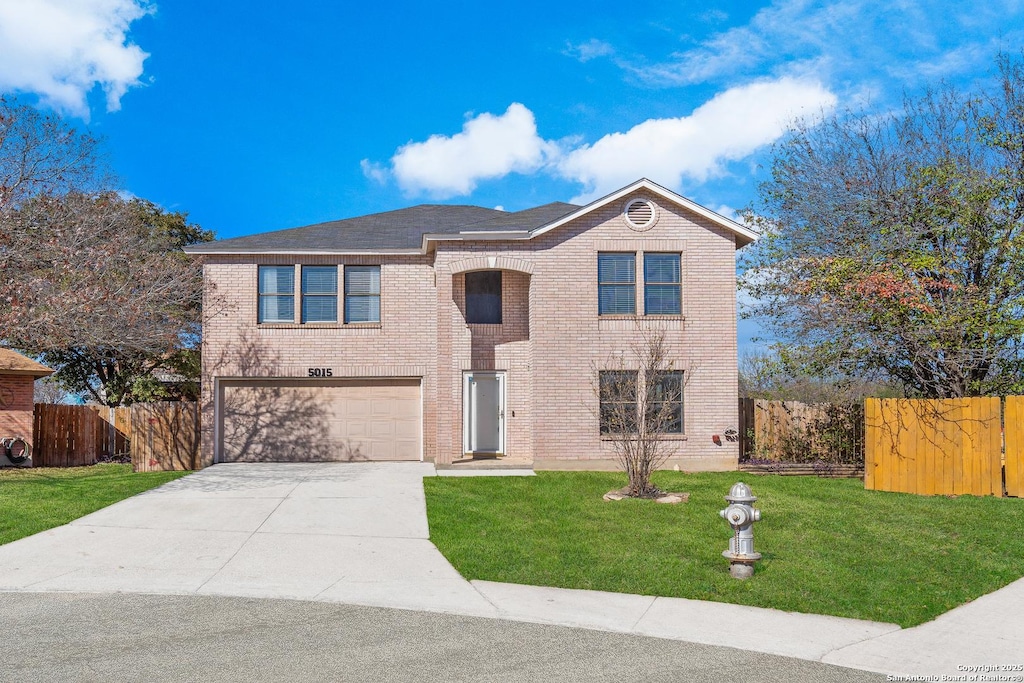 view of property featuring a garage and a front lawn