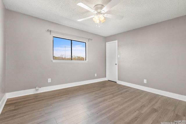 unfurnished room with ceiling fan, wood-type flooring, and a textured ceiling