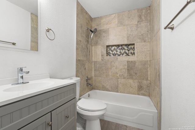 full bathroom with hardwood / wood-style flooring, toilet, vanity, and tiled shower / bath