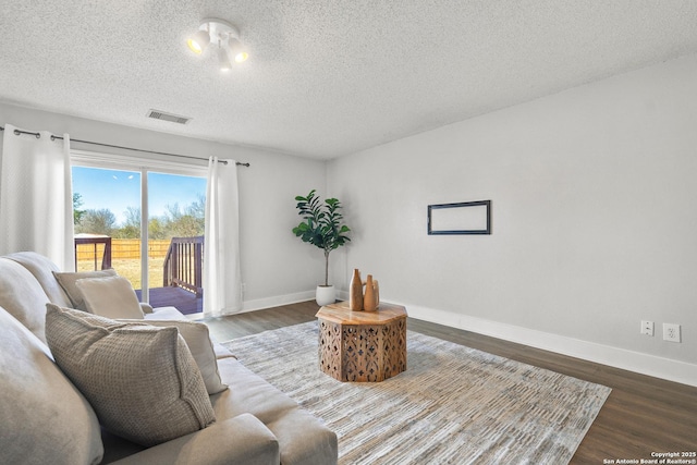 living room featuring a textured ceiling and dark hardwood / wood-style floors