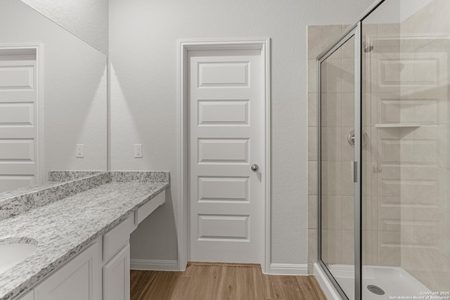 bathroom featuring hardwood / wood-style floors, vanity, and an enclosed shower