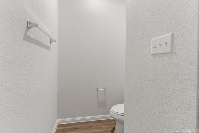 bathroom featuring hardwood / wood-style flooring and toilet