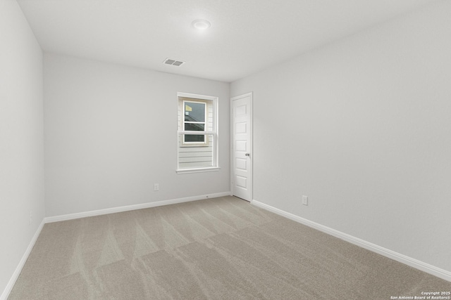 spare room featuring light colored carpet