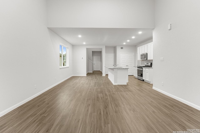 unfurnished living room featuring light hardwood / wood-style flooring and sink