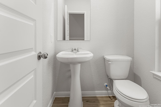 bathroom featuring hardwood / wood-style floors, toilet, and sink