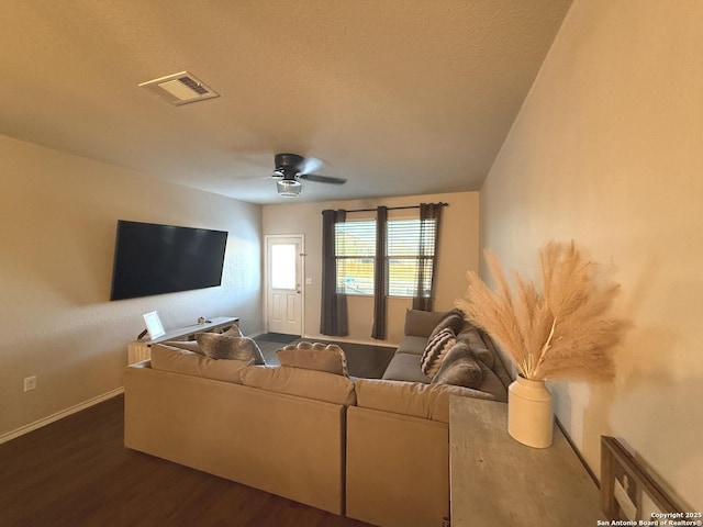 living room featuring ceiling fan and dark hardwood / wood-style floors