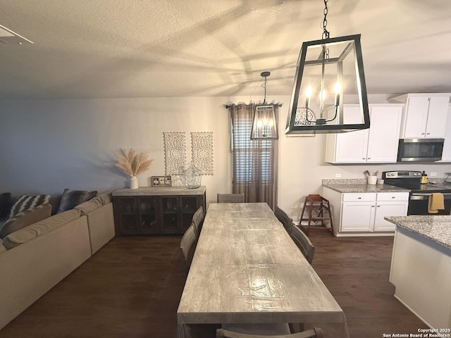 kitchen with pendant lighting, white cabinets, a textured ceiling, dark hardwood / wood-style flooring, and stainless steel appliances