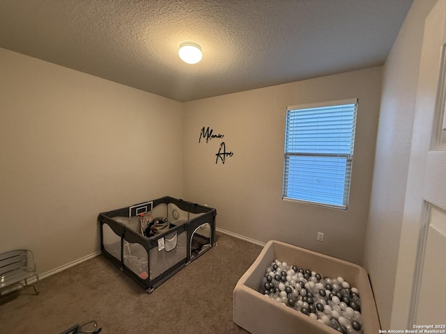 bedroom with dark colored carpet, a textured ceiling, and multiple windows