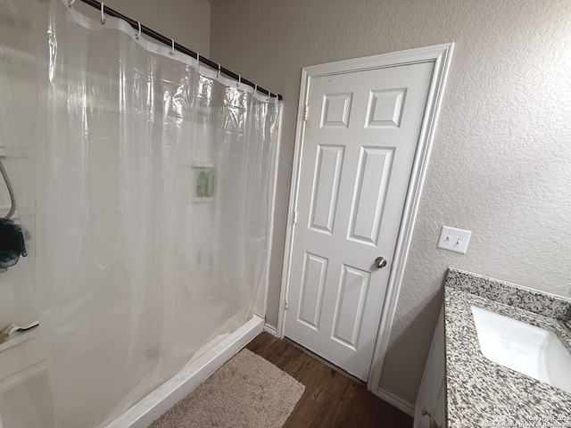 bathroom featuring hardwood / wood-style floors, vanity, and walk in shower