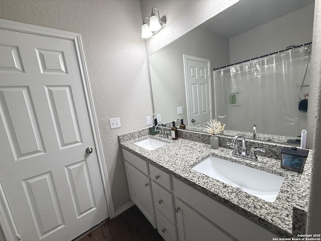 bathroom featuring curtained shower and vanity