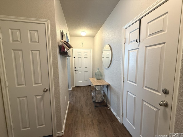 hallway with dark hardwood / wood-style flooring and a textured ceiling