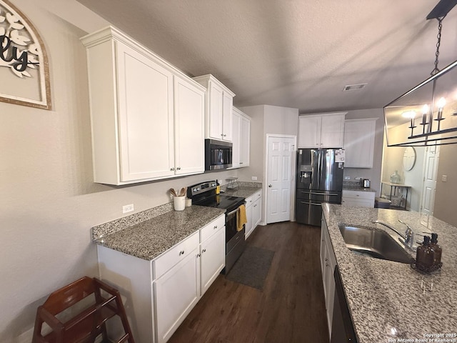 kitchen featuring white cabinetry, sink, dark wood-type flooring, dark stone counters, and appliances with stainless steel finishes