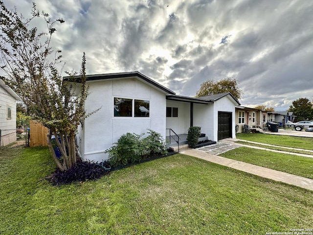 view of front of home with a garage and a front lawn