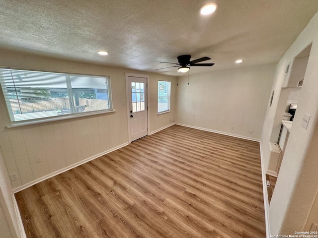 empty room with wood-type flooring, a textured ceiling, and ceiling fan