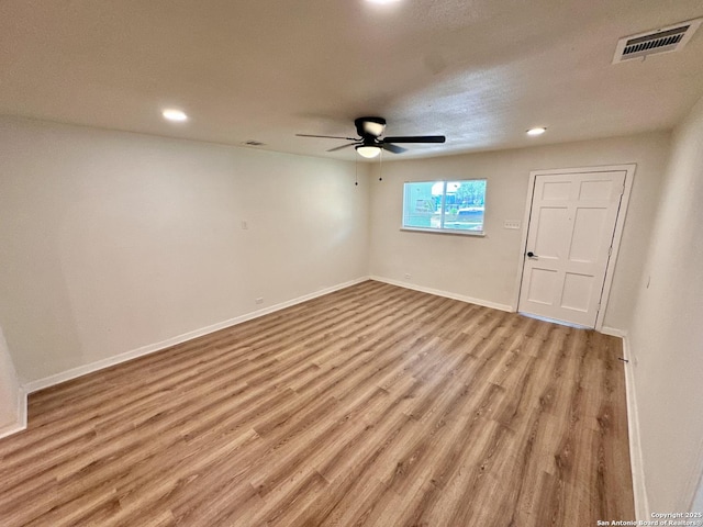 empty room with ceiling fan, light hardwood / wood-style floors, and a textured ceiling