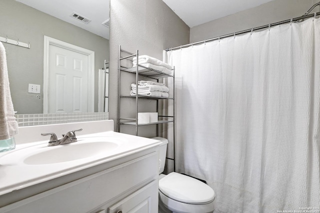 bathroom featuring walk in shower, vanity, and toilet